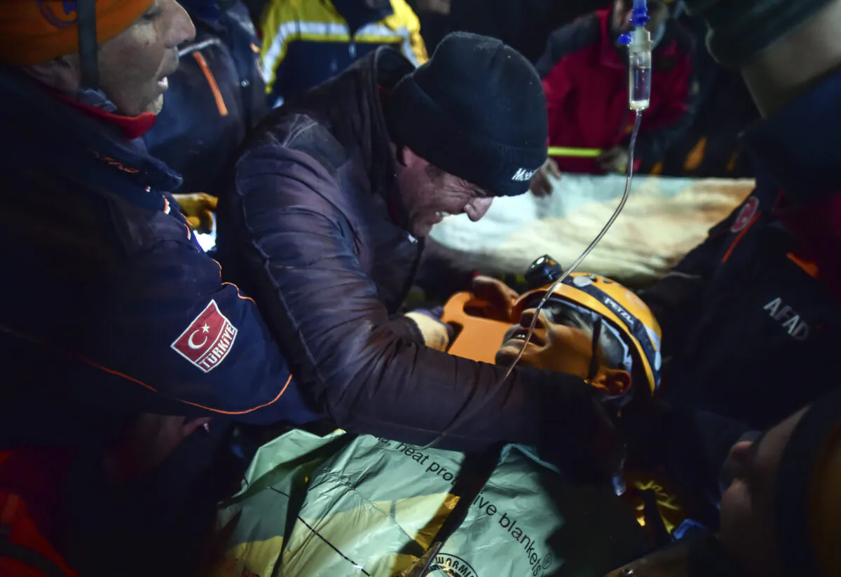 Turkish rescue workers carry Kamil Can Agdas to an ambulance after they pulled him out from a collapsed building five days after the earthquake, in Kahramanmaras, southern Turkey, on Feb. 11, 2023. (Ismail Coskun/IHA via AP Photo)