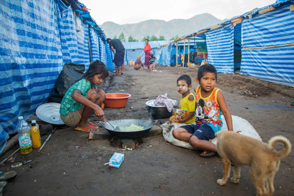 This photo taken on February 14, 2022 shows Myanmar refugee children, who fled a surge in violence as the military cracks down on rebel groups, cooking at a camp in Nawphewlawl near the Myanmar-Thailand border in Kayin state. (Photo by AFP) (Photo by STR/AFP via Getty Images)