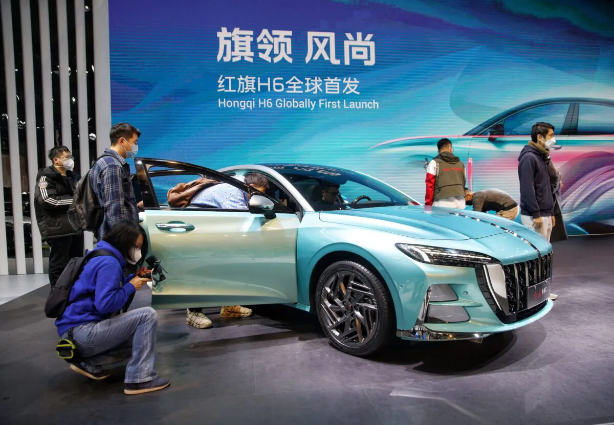 Visitors look at a Hongqi H6 on the opening day of the 20th Guangzhou International Automobile Exhibition in Guangzhou, China, on Dec. 30, 2022. (STR/AFP via Getty Images)