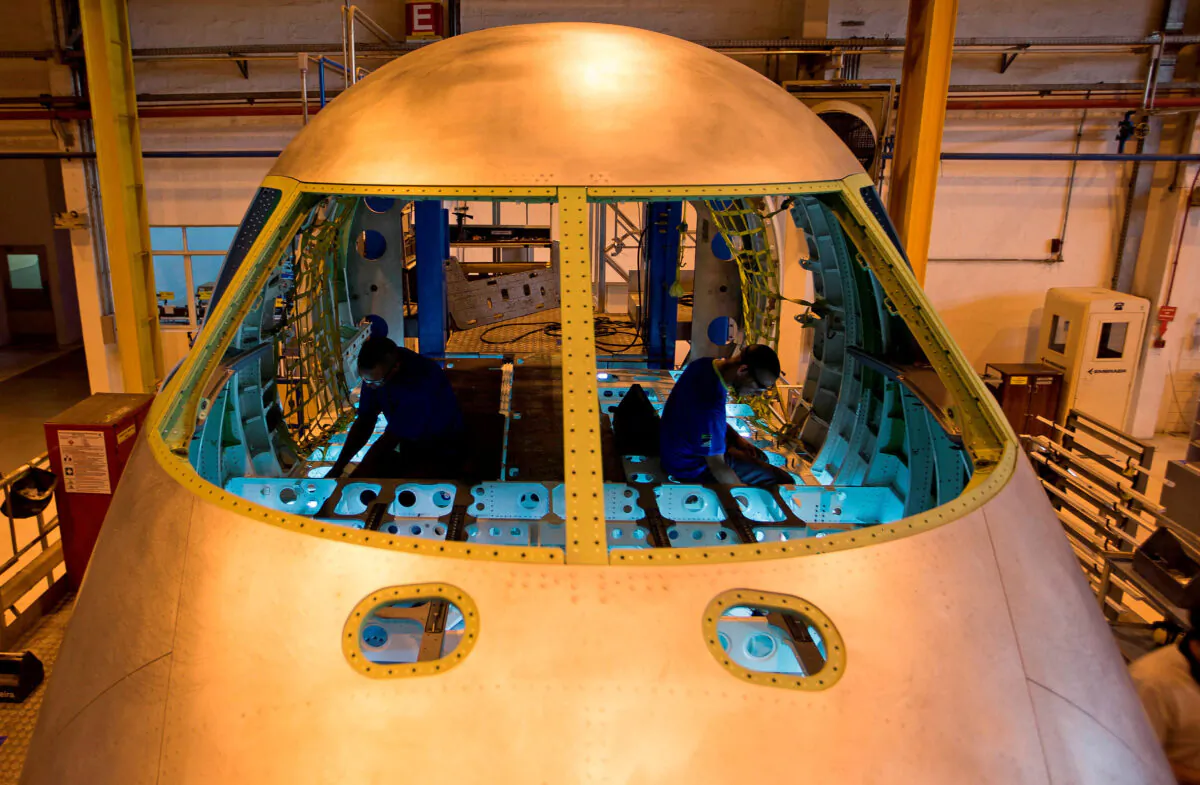 Technicians work on the assembly line of Embraer's E-Jet family of commercial planes at their factory in Sao Jose dos Campos, Brazil, on Oct. 16, 2014. (Roosevelt Cassio/Reuters)