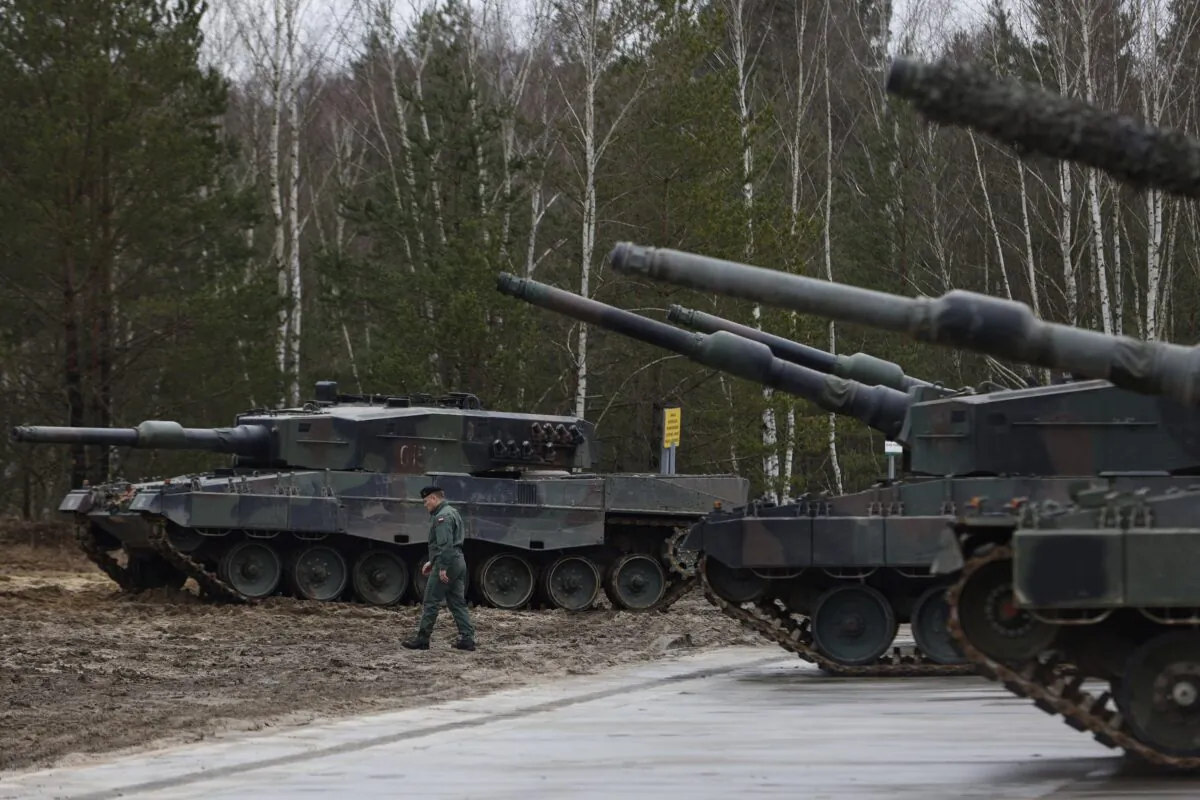 A Polish soldier walks next to the Leopard 2 tanks during a training at a military base and test range in Swietoszow, Poland, on Feb. 13, 2023. (Michal Dyjuk/AP Photo)