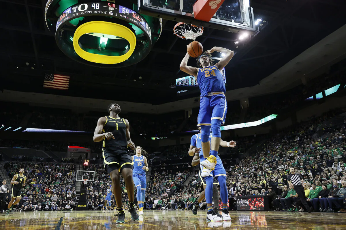 Jaime Jaquez Jr. (24) of the UCLA Bruins dunks the ball as N'Faly Dante (1) of the Oregon Ducks looks on during the second half at Matthew Knight Arena in Eugene, Ore., on Feb. 11, 2023. (Soobum Im/Getty Images)