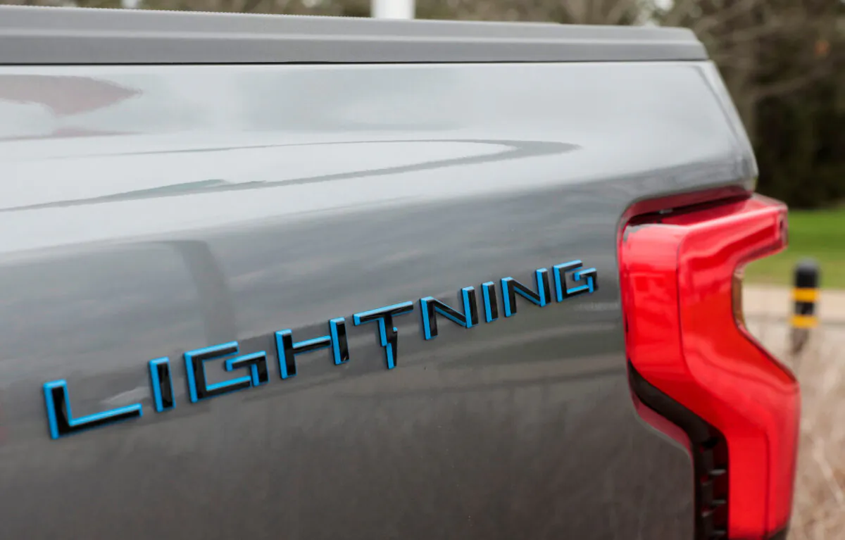 The Lightning logo on the side of an all-new Ford F-150 Lightning electric pickup truck outside the Ford Motor World Headquarters in Dearborn, Mich., on April 26, 2022. (Rebecca Cook/Reuters) 