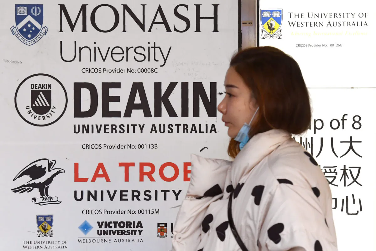 A woman walks past signage for Australian universities in Melbourne, Australia, on June 10, 2020. (William West/AFP via Getty Images)