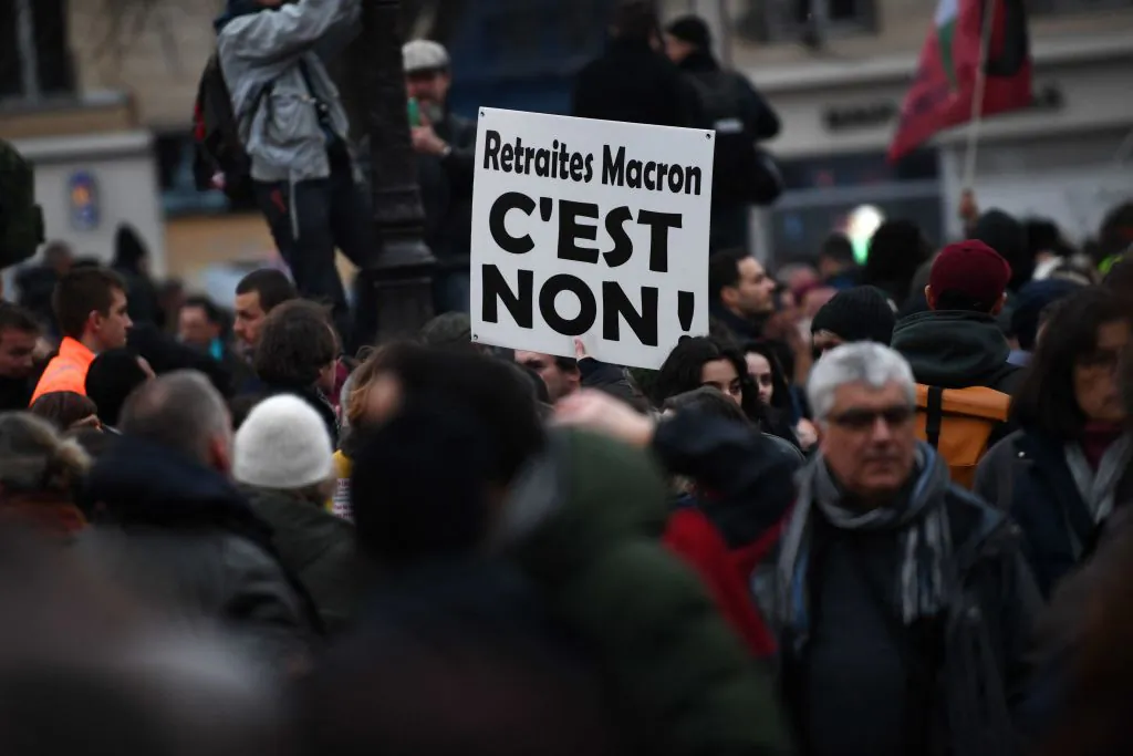 A protester holds a placard reading "Macron pensions, it's no!" during a demonstration on the fourth day of nationwide rallies organised since the start of the year, against a deeply unpopular pensions overhaul, in Paris, on Feb. 11, 2023. (Christophe Archambault/AFP via Getty Images)