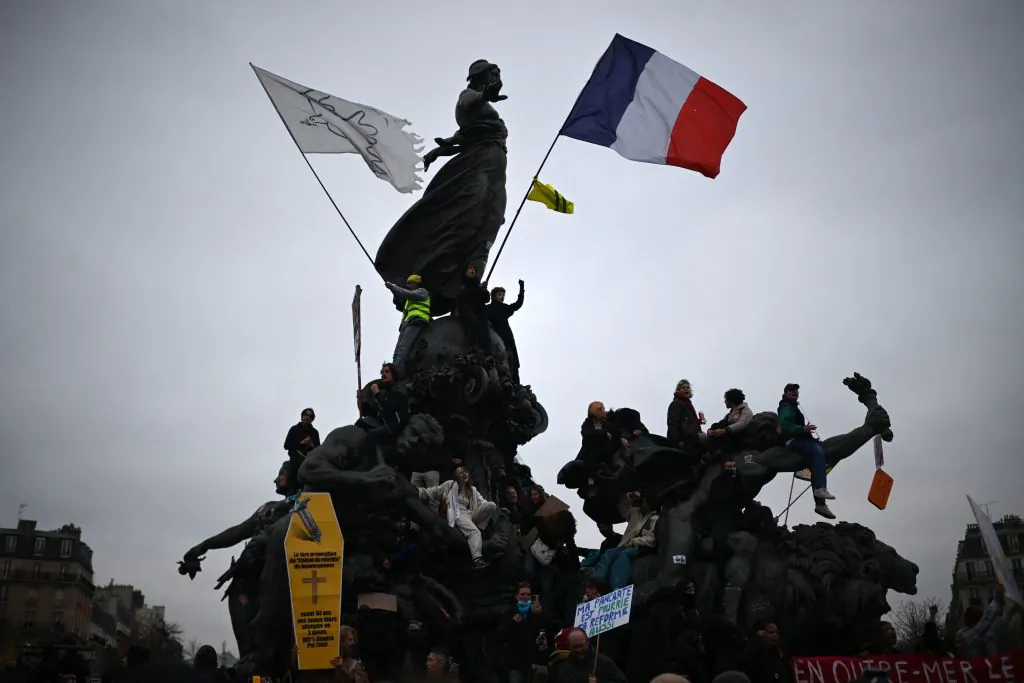 Protesters climb on the bronze statue "Le Triomphe de la Republique" (The triumph of the Republic) by Jules Dalou during a demonstration on the fourth day of nationwide rallies organised since the start of the year, against a deeply unpopular pensions overhaul, on Nation Square in Paris, on Feb. 11, 2023. (Christophe Archambault/AFP via Getty Images)