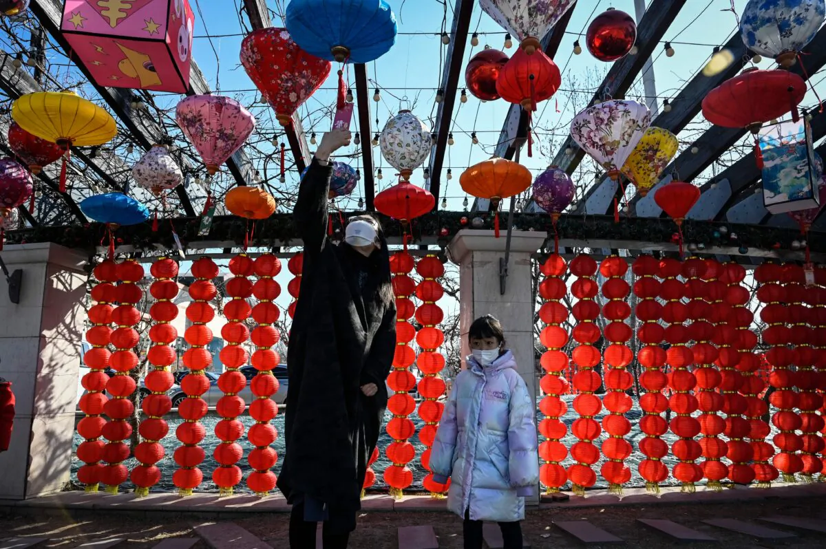 A person reads a riddle hung from a lantern on display at a shopping mall in Beijing on Feb. 4, 2023. (Jade Gao/AFP via Getty Images)