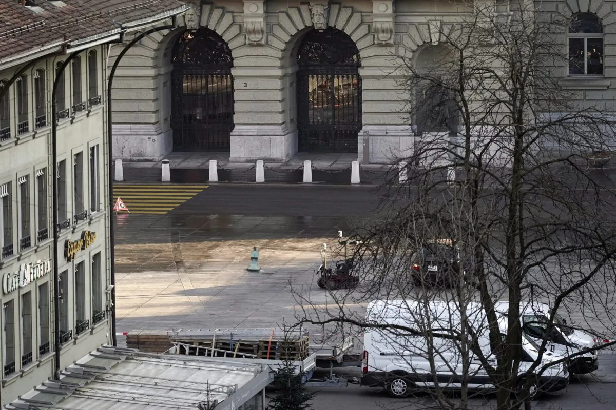 A police robot stands next to a suspicious car in front of the Swiss Parliament, the Bundeshaus in Bern, during the large-scale operation of the Bern police, where several buildings were evacuated and the Bundesplatz and some streets around were widely cordoned off, on Feb. 14, 2023. (Manuel Lopez/Keystone via AP)