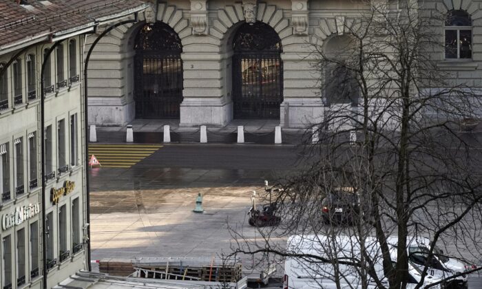 A police robot stands next to a suspicious car in front of the Swiss parliament during a major Bern police operation. February 14, 2023 (Manuel Lopez/Keystone via AP)