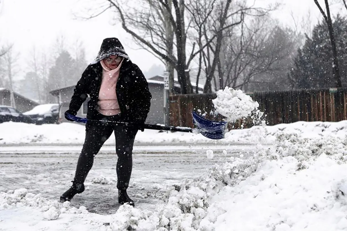 Taja Cantlon clears chunks of snow left by a snowplow from out of her driveway entrance in Flagstaff, Ariz., on Feb. 14, 2023. (Rachel Gibbons/The Daily News-Sun via AP)