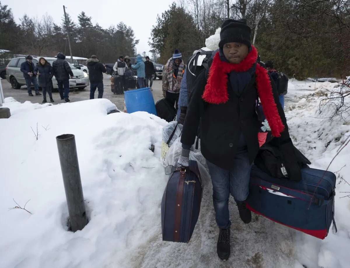 Asylum seekers from Congo cross the unofficial border at Roxham Road into Quebec, from Champlain, New York, on Feb. 9, 2023. (The Canadian Press/Ryan Remiorz)