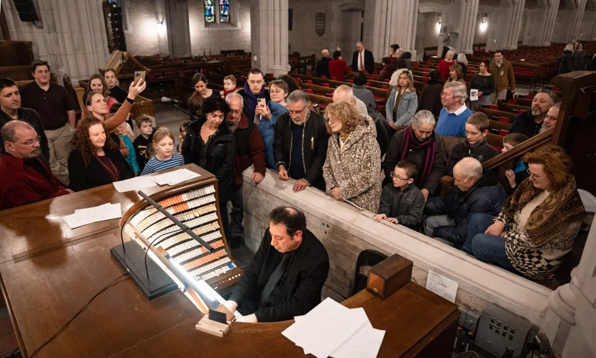 Attendees have a closer look at the organ's console as Salvatore Pronestì improvises at the Cadet Chapel at West Point, N.Y., on Feb. 12, 2023.(Samira Bouaou/The Epoch Times)