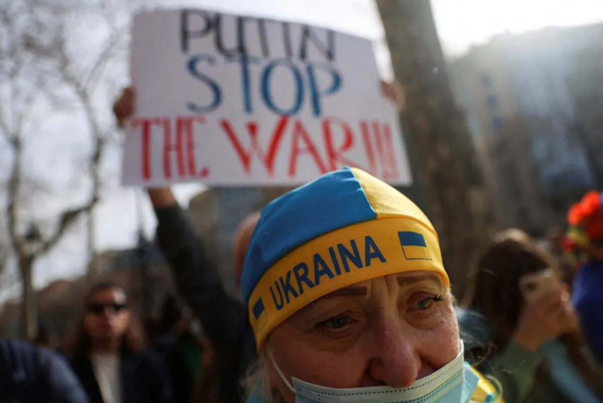 A demonstrator wears a hat with a Ukrainian flag at an anti-war protest in front of the European Union headquarters, in Barcelona, Spain, on Feb. 24, 2022. (Nacho Doce/Reuters)