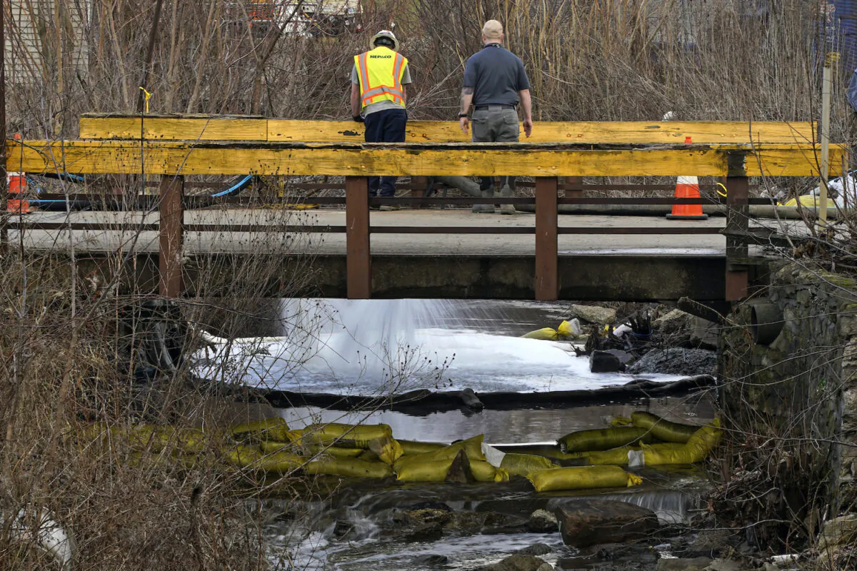 HEPACO workers, an environmental and emergency services company, observe a stream in East Palestine, Ohio, on Feb. 9, 2023 as the cleanup continues after the derailment of a Norfolk Southern freight train. (Gene J. Puskar/AP Photo)