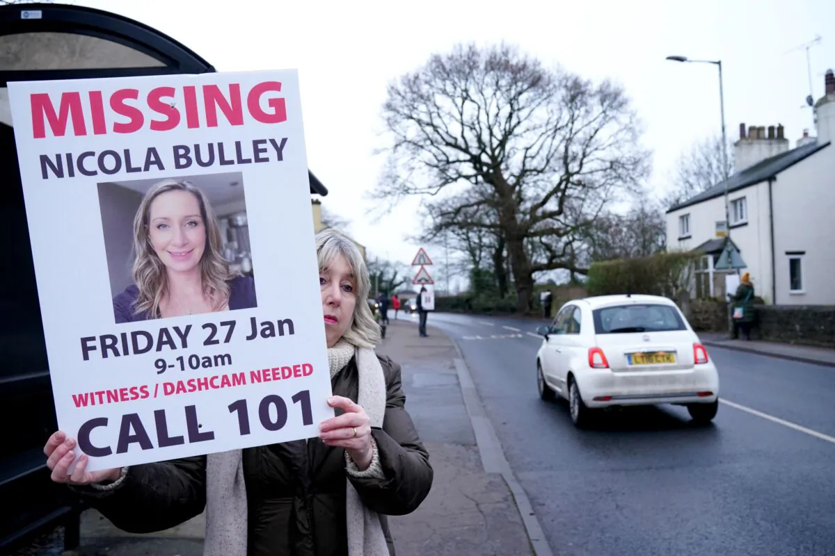 A woman holds up a placard during search for Nicola Bulley, who went missing in Lancashire, England, on Jan. 27, 2023. (PA)