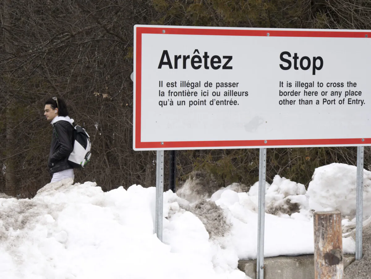A man waits for transportation at the unofficial border at Roxham Road into Canada in Hemmingford, Que., on Feb. 9, 2023. (Ryan Remiorz/The Canadian Press)