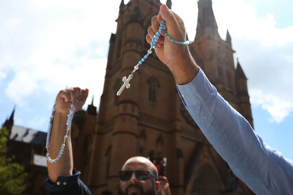 Catholic worshippers signal towards protesters outside St. Mary’s Cathedral during the pontifical requiem Mass for Cardinal George Pell in Sydney, Australia, on Feb. 2, 2023. (Lisa Maree Williams/Getty Images)