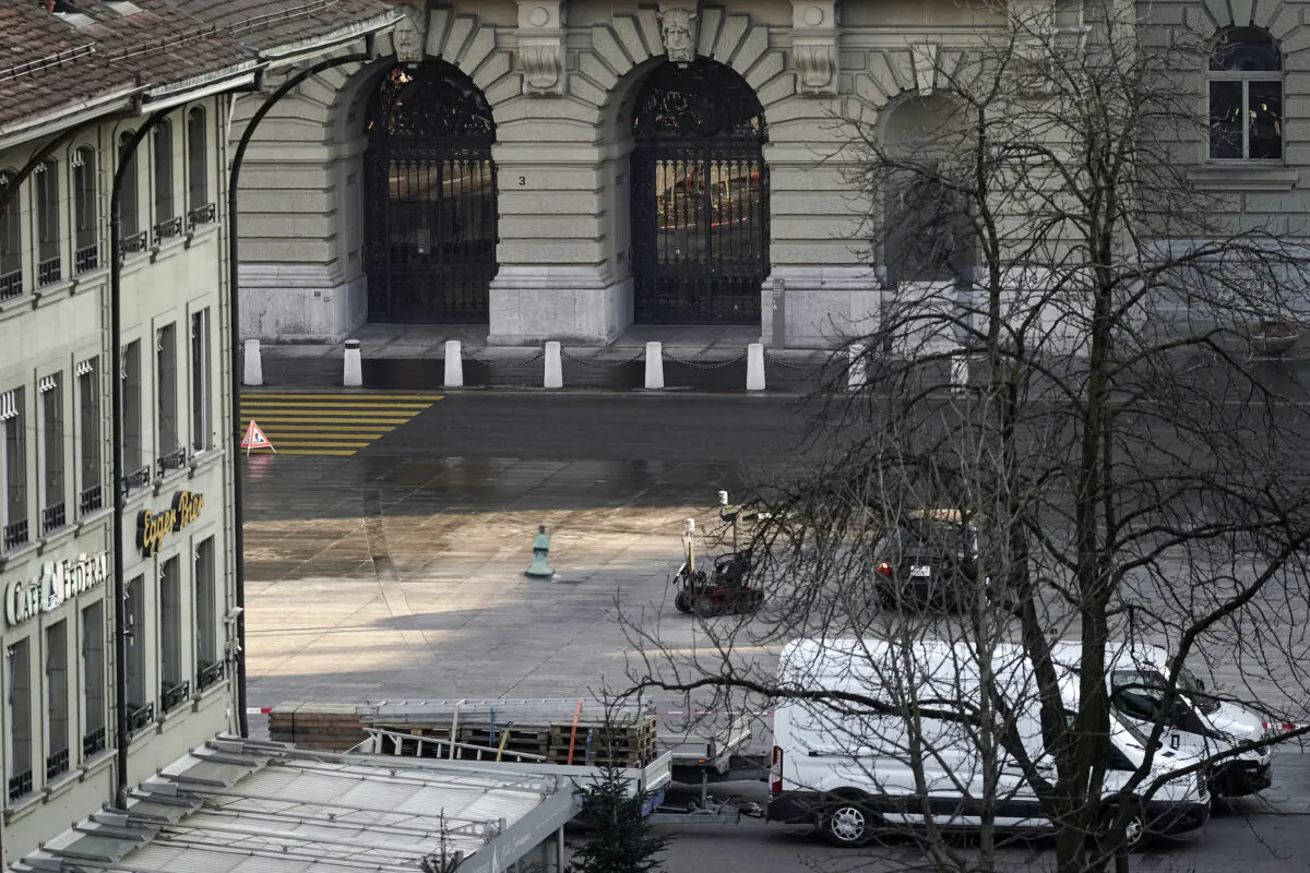 A police robot stands next to a suspicious car in front of the Swiss Parliament, the Bundeshaus in Bern, during the large-scale operation of the Bern police, where several buildings were evacuated and the Bundesplatz and some streets around were widely cordoned off, on Feb. 14, 2023. (Manuel Lopez/Keystone via AP)