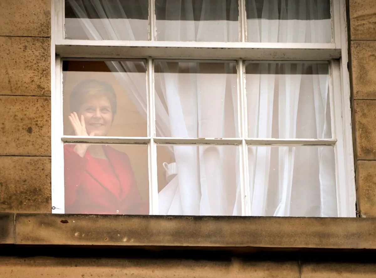Nicola Sturgeon - who resigned as Scotland's First Minister on Wednesday - waves out of the window of Bute House in Edinburgh, Scotland on Feb. 15, 2023. (PA)