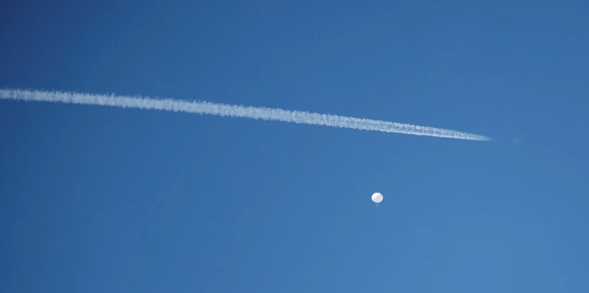 A jet flies by a suspected Chinese spy balloon as it floats off the coast in Surfside Beach, South Carolina, on Feb. 4, 2023. (Randall Hill/Reuters)