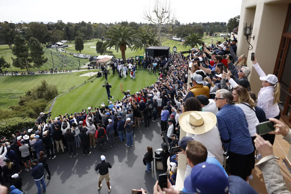 The gallery watches Tiger Woods, bottom left, as hits from the first tee during the first round of the Genesis Invitational golf tournament at Riviera Country Club, in the Pacific Palisades area of Los Angeles on, Feb. 16, 2023. (Ryan Kang/AP Photo)