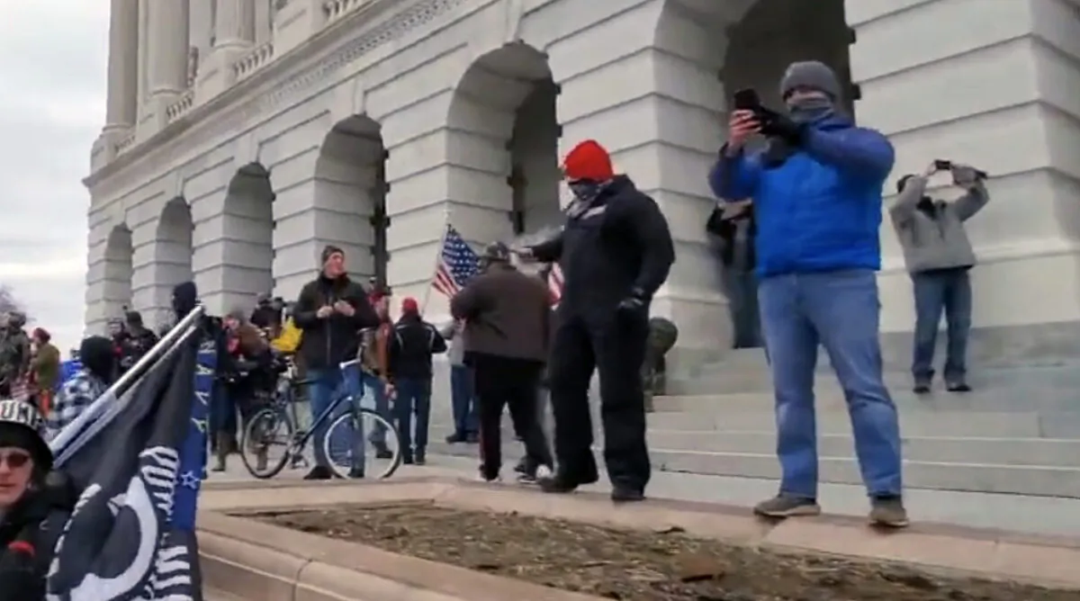Two undercover Metropolitan Police Department officers (red and grey caps) outside the U.S. Capitol in Washington on Jan. 6, 2021. (Archive.org/Screenshot via The Epoch Times)