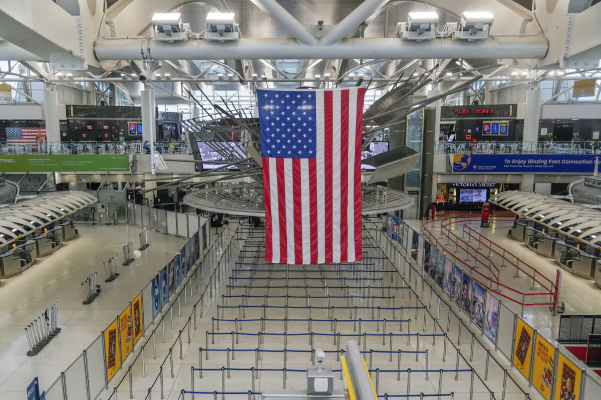 An American flag hangs over a mostly empty Terminal 1 at John F. Kennedy International Airport in New York on Feb. 17, 2023. (Seth Wenig/AP Photo)