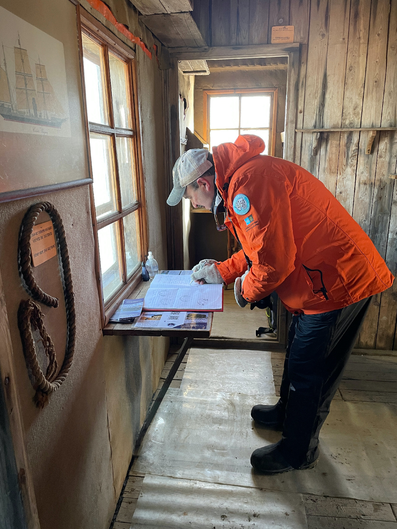 A visitor signs the guest log in tiny Nordenskjold's Hut on Snow Island in Antarctica where six researchers in the Heroic Age of Antarctica Exploration were stuck for 22 months.