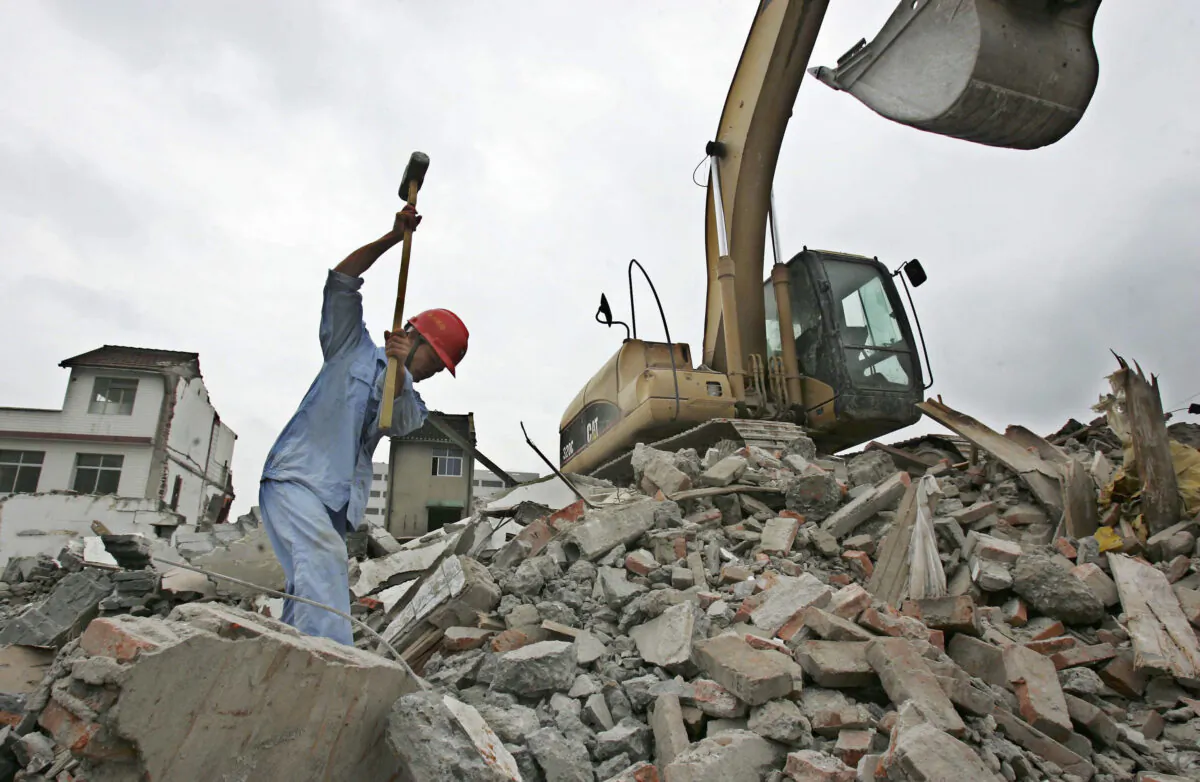 A man works at a demolition site in the Bailianjing Area in Pudong District, where residential houses were being demolished in Shanghai, China, on Aug. 28, 2005. (China Photos/Getty Images)