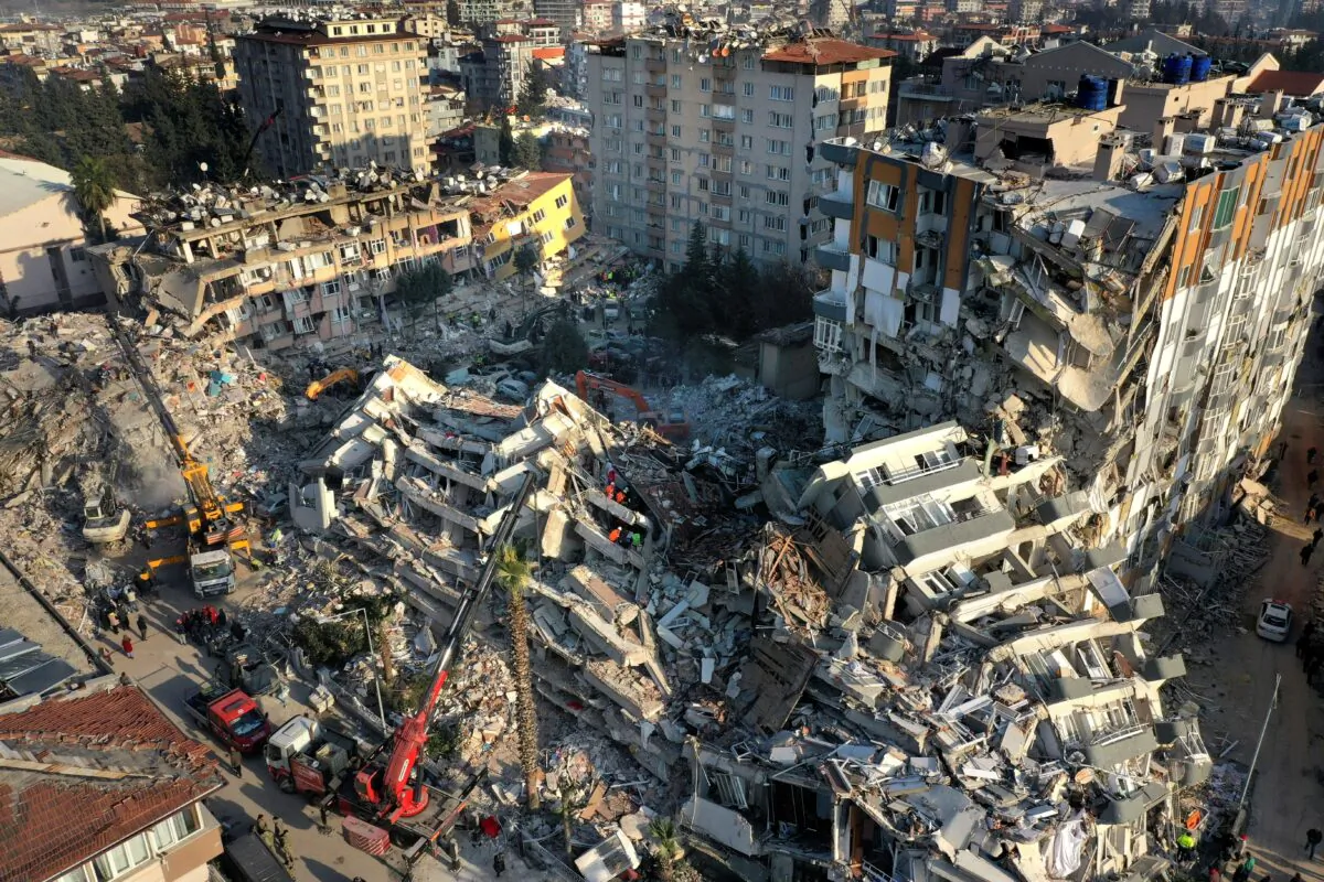 Rescue teams search for people as cranes remove debris from destroyed buildings in Antakya, southeastern Turkey, on Feb. 10, 2023. (Hussein Malla/AP Photo)