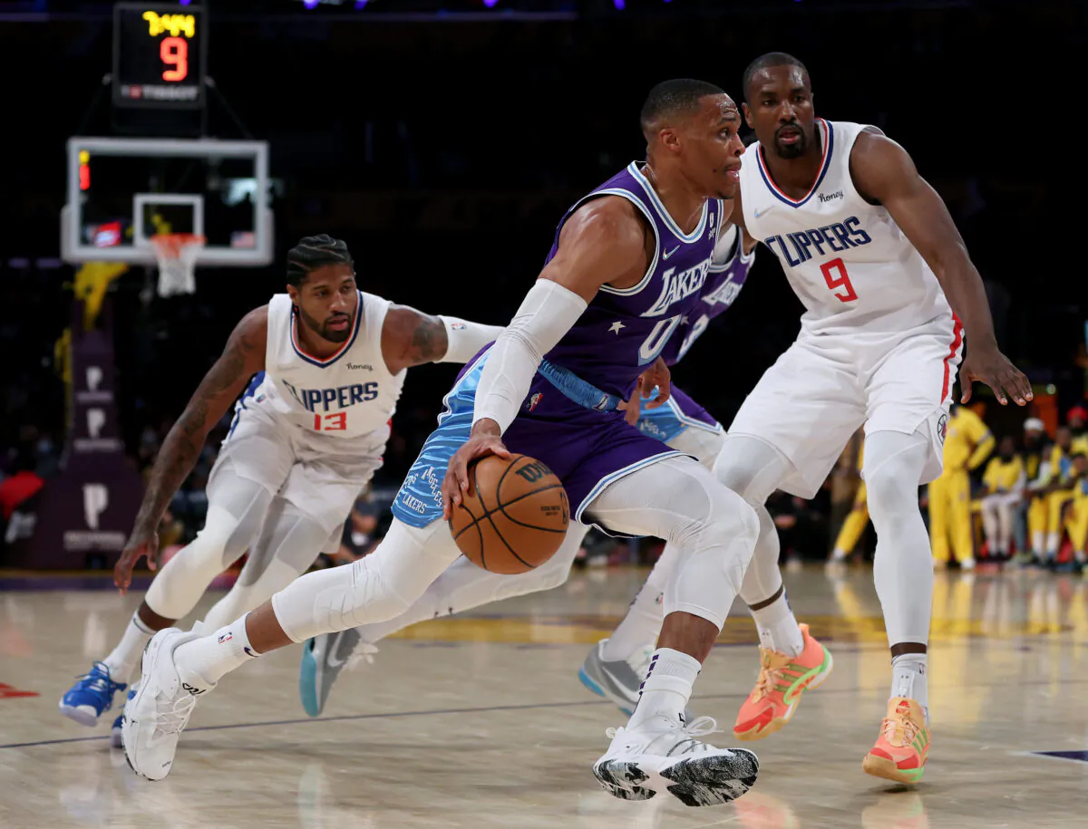 Russell Westbrook (0) of the Los Angeles Lakers drives past Paul George (13) and Serge Ibaka (9) of the LA Clippers during the first half at Staples Center in Los Angeles on Dec. 3, 2021. (Harry How/Getty Images)