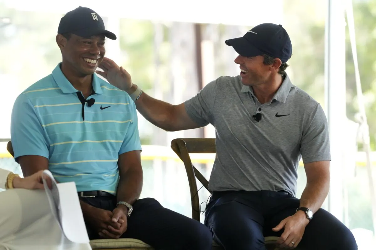 Golfers Tiger Woods (L) and Rory McIlroy share a laugh as they discuss the future home of their tech-infused golf league that will begin play next year on the campus of Palm Beach State College in Palm Beach Gardens, Fla., on Feb. 21, 2023. (Wilfredo Lee/AP Photo)
