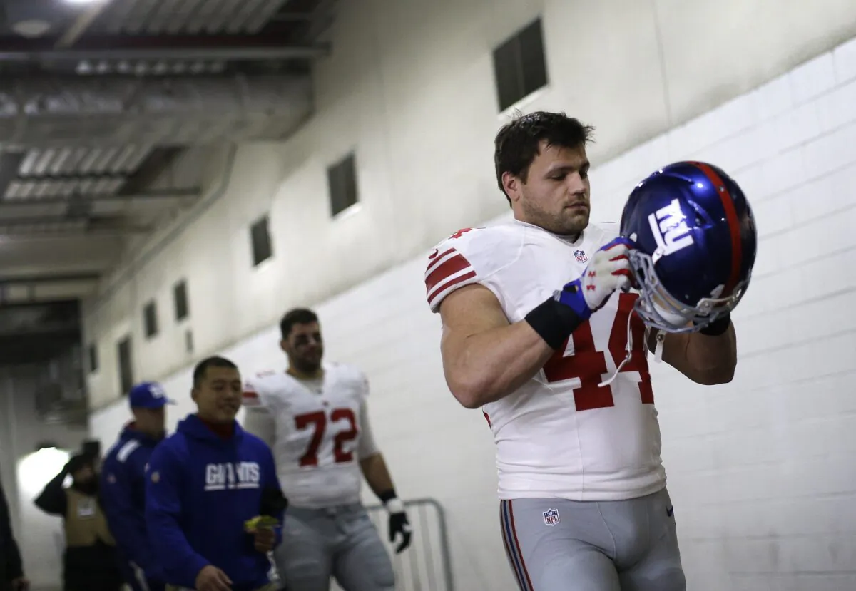New York Giants running back Peyton Hillis puts his helmet on as he walks through a tunnel to the field before an NFL football game against the Washington Redskins in Landover, Md., on Dec. 1, 2013. (Patrick Semansky/AP Photo)