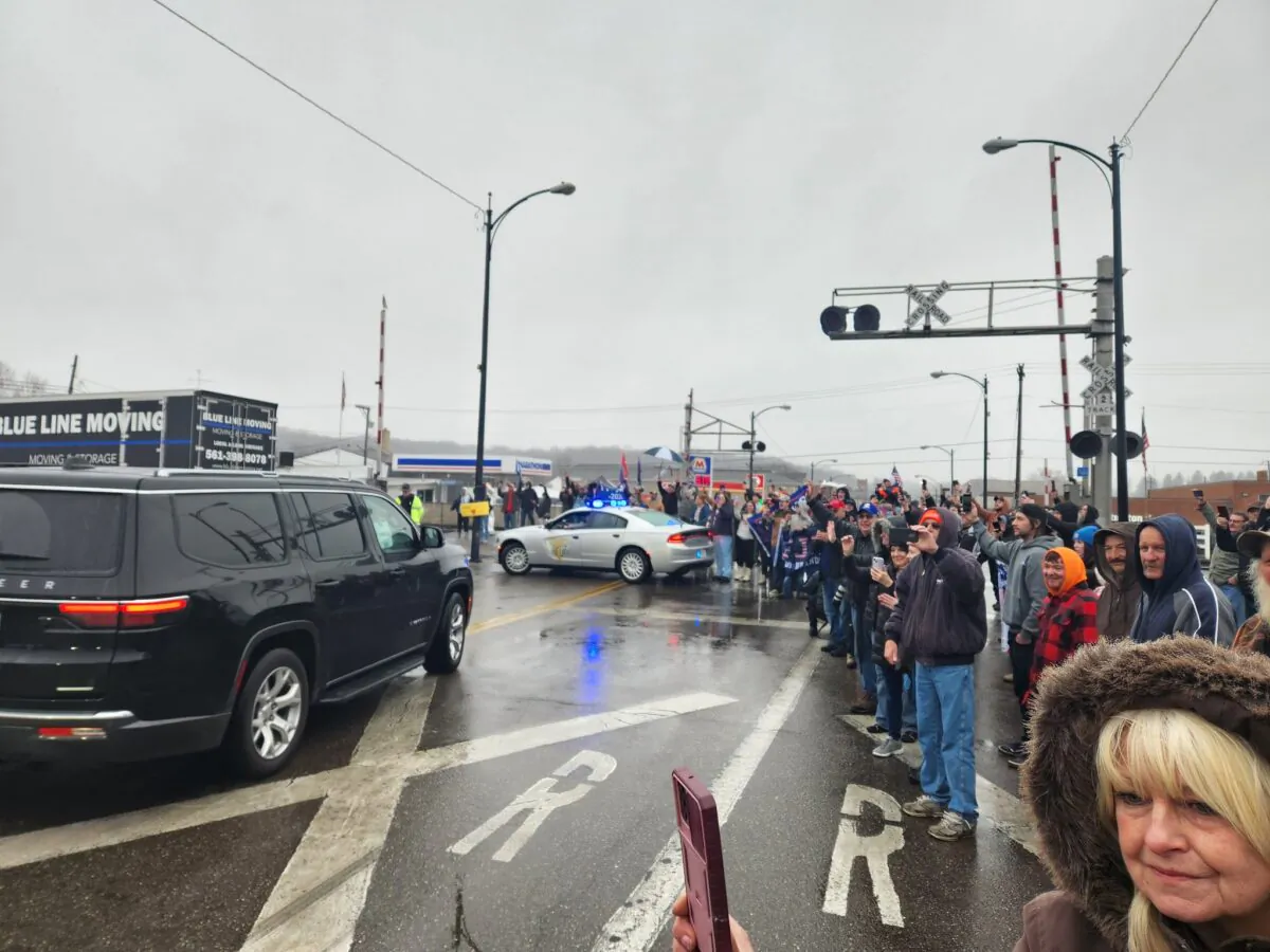Supporters of former President Donald Trump line the streets of East Palestine, Ohio, to catch a glimpse of him as he drives by. (Jeff Louderback/The Epoch Times)