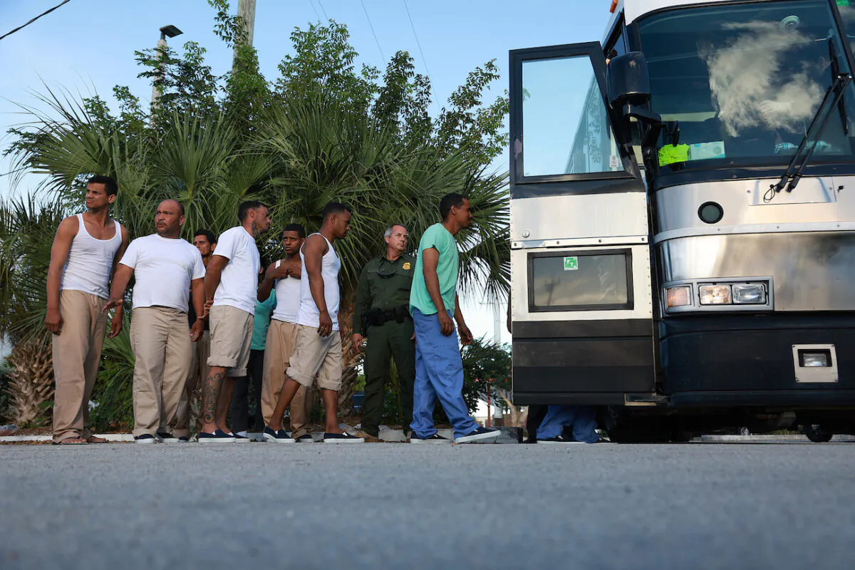 Illegal immigrants from Cuba line up to board a bus to be driven to a U.S. Customs and Border Protection station as they are processed in Marathon, Fla., on Jan. 5, 2023. (Joe Raedle/Getty Images)