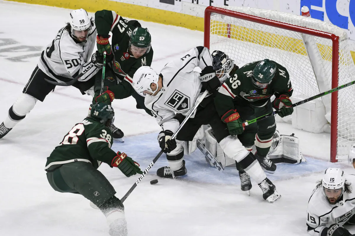 Los Angeles Kings defenseman Matt Roy, center, and defenseman Sean Durzi (50) try to clear the puck from the goal as Minnesota Wild right wing Mats Zuccarello (36), left wing Kirill Kaprizov (97) and right wing Ryan Hartman try to score during the first period of an NHL hockey game in St. Paul, Minn., on Feb. 21, 2023. (Craig Lassig/AP Photo)