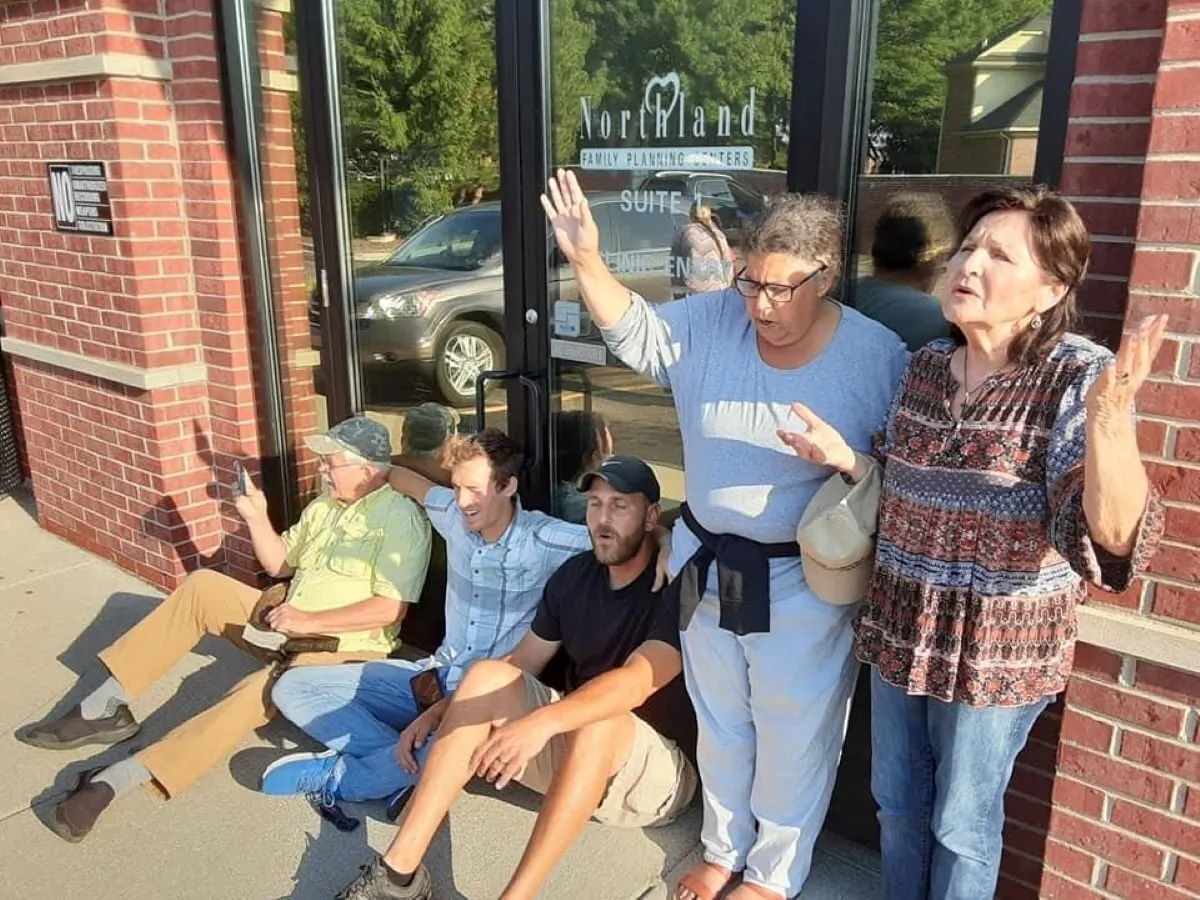Pro-life activists sit in front of abortion facility door in Sterling Heights, Michigan, August, 27, 2020. (Cal Zastrow)