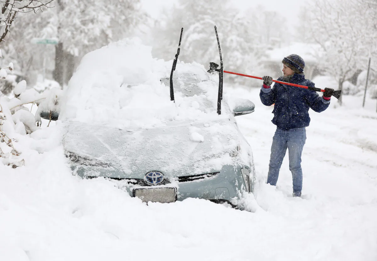 Cathy Morgan-Mace cleans snow and ice off her family's car during a snowstorm in Salt Lake City, Utah, on Wednesday, Feb. 22, 2023. A brutal winter storm knocked out power in California, closed interstate highways from Arizona to Wyoming and prompted more than 1,200 flight cancellations Wednesday — and the worst won't be over for several days. (Kristin Murphy/The Deseret News via AP)