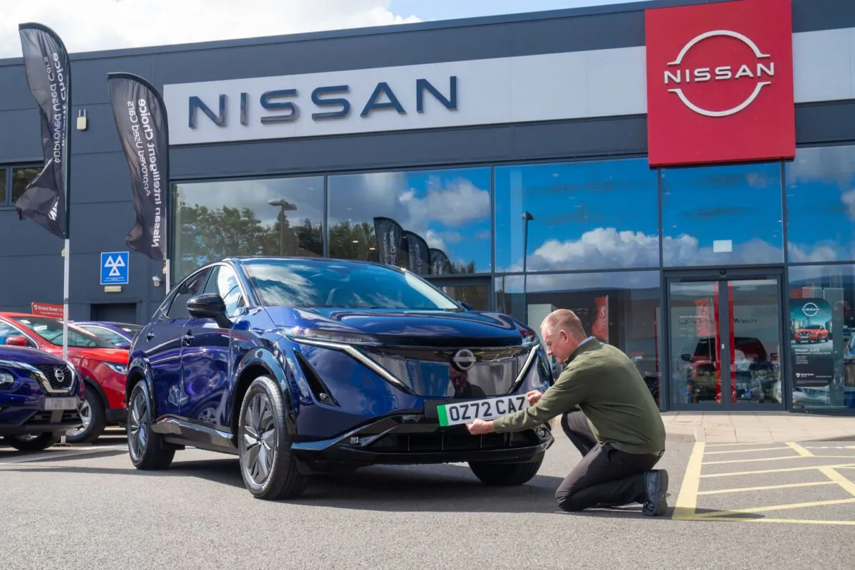 A new number plate is put on a brand new Nissan electric car at a dealership in Northampton, England, on Aug. 5, 2022. (Blackball Media/PA)
