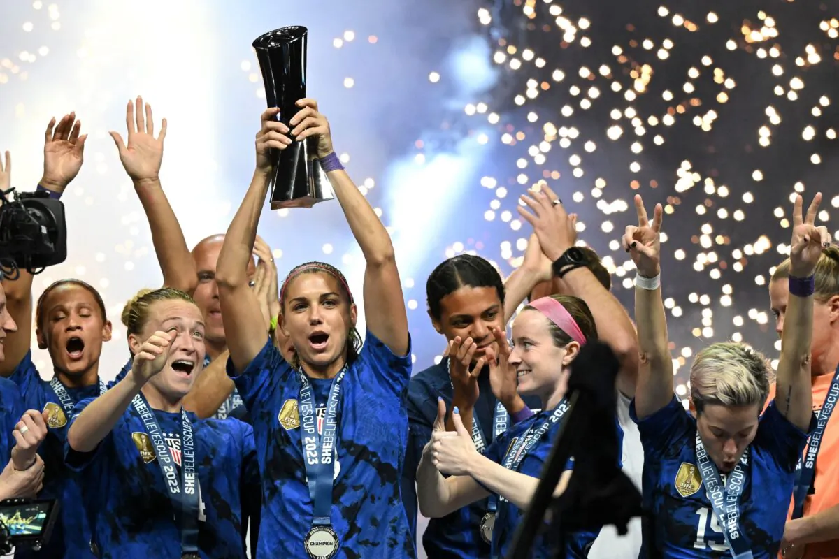 United States forward Alex Morgan (C) raises the SheBelieves Cup trophy as the United States Women's National Soccer Team celebrates following the 2023 SheBelieves Cup soccer match between the United States and Brazil at Toyota Stadium in Frisco, Texas, on Feb. 22, 2023. (Patrick T. Fallon / AFP via Getty Images)