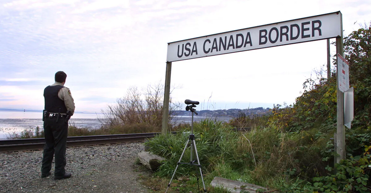 A Canadian Customs and Fisheries officer stands at the U.S.-Canada border between Blaine, Washington, and White Rock, British Columbia, on Nov. 8, 2001. (Jeff Vinnick/Getty Images)