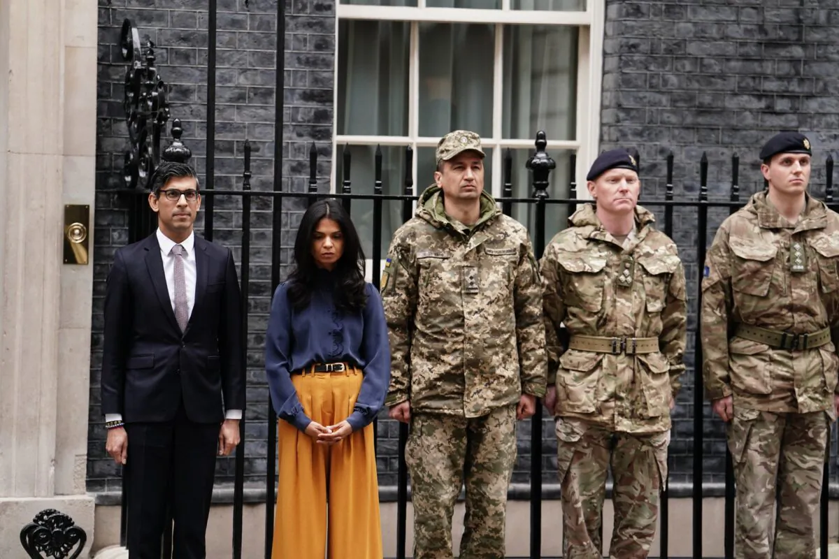 Prime Minister Rishi Sunak and his wife Akshata Murty with members of the Ukrainian Armed Forces, as they observe a minute's silence to mark the one-year anniversary of the Russian invasion of Ukraine, outside 10 Downing Street, London, on Feb. 24, 2023. (Jordan Pettitt/PA Media)