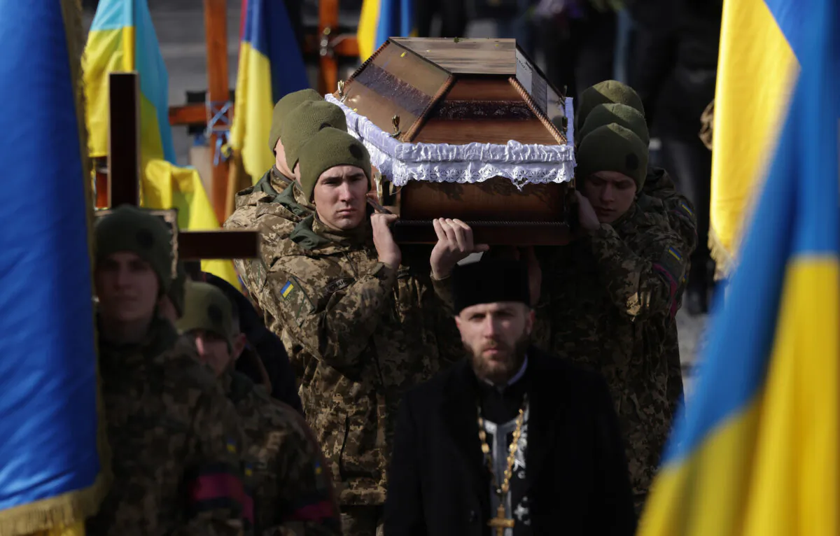 Soldiers carry the coffin of soldier Vladyslav Tkachenko, 45, at his funeral and that of a second soldier at the Field of Mars cemetery in Lviv, Ukraine, on Feb. 22, 2023. Both men were volunteer soldiers serving in a Ukrainian territorial defense unit and were killed in eastern Ukraine. (Sean Gallup/Getty Images/TNS)