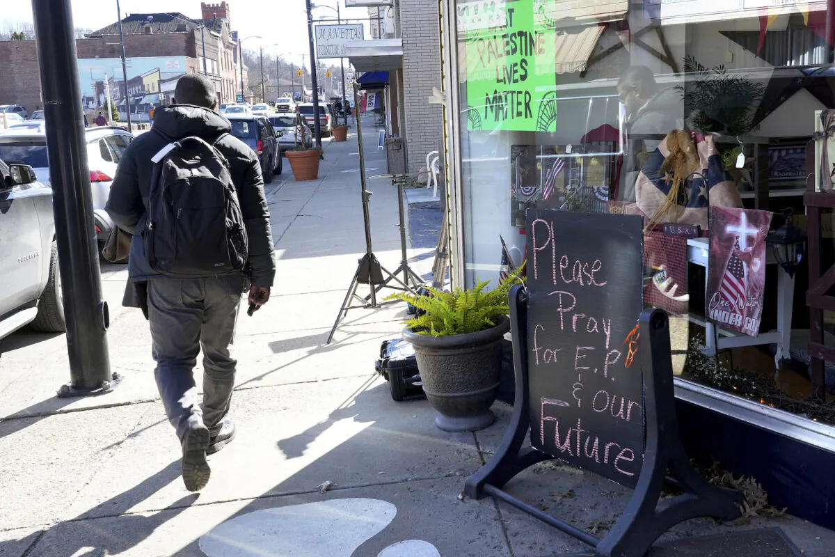 A pedestrian walks down the street in East Palestine, Ohio, as cleanup from the Feb. 3 Norfolk Southern train derailment continues, on Feb. 24, 2023. (AP Photo/Matt Freed)