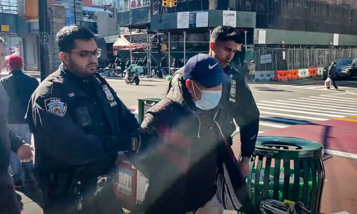Police arrest Qi Zhongping, who faces charges for assaulting Falun Gong practitioners in the Flushing neighborhood of Queens, N.Y., on Feb. 18, 2023. (Screenshot via The Epoch Times)