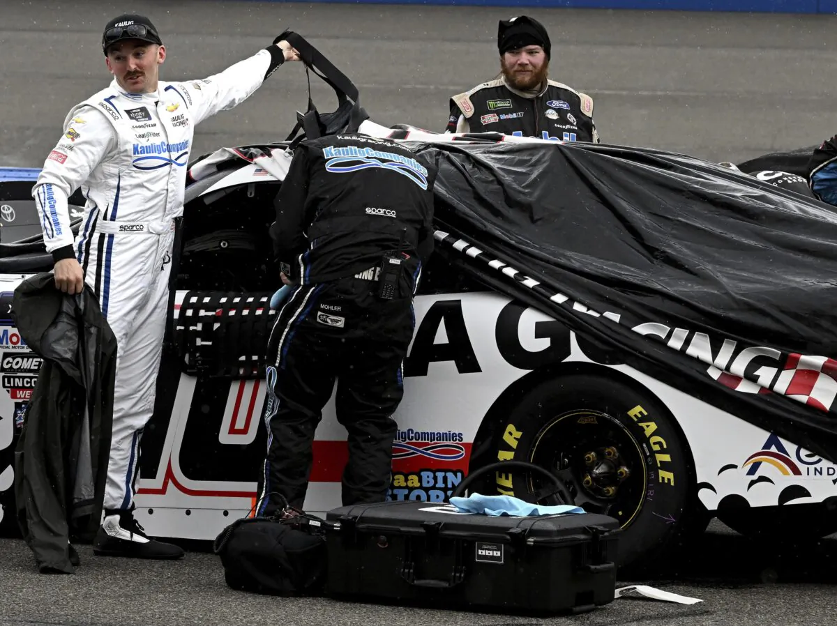 Austin Dillon stands next to his car after returning to the pits when the NASCAR Xfinity Series race was postponed at Auto Club Speedway in Fontana, Calif., on Feb. 25, 2023. (Will Lester/The Orange County Register via AP)
