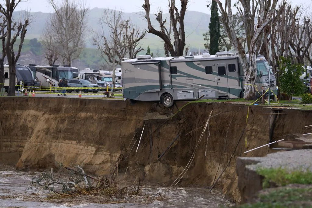 An RV begins to fall into the Santa Clara River as the ground bellow it is washed away by flooding due to heavy rain washing away over 150 feet of land and multiple RV homes in Castaic, Calif., on Feb. 25, 2023. (Allison Dinner/AFP via Getty Images)