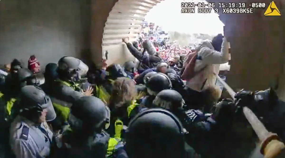 Metropolitan Police Department Officer Michael Dowling uses a flagpole to jab at a protester in the Lower West Terrace tunnel at the U.S. Capitol on Jan. 6, 2021. (Metropolitan Police Department/Screenshot via The Epoch Times)