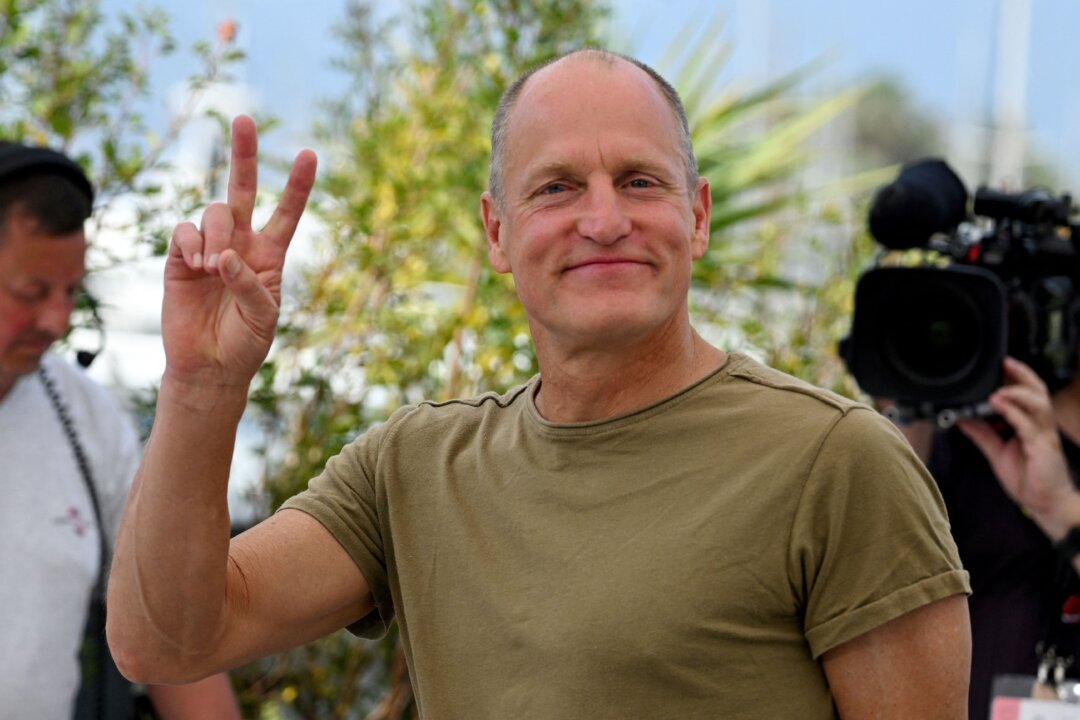 U.S. actor Woody Harrelson flashes the victory sign during a photocall for the film "Triangle of Sadness" at the 75th edition of the Cannes Film Festival in Cannes, southern France, on May 22, 2022. (Christophe Simon/AFP via Getty Images)