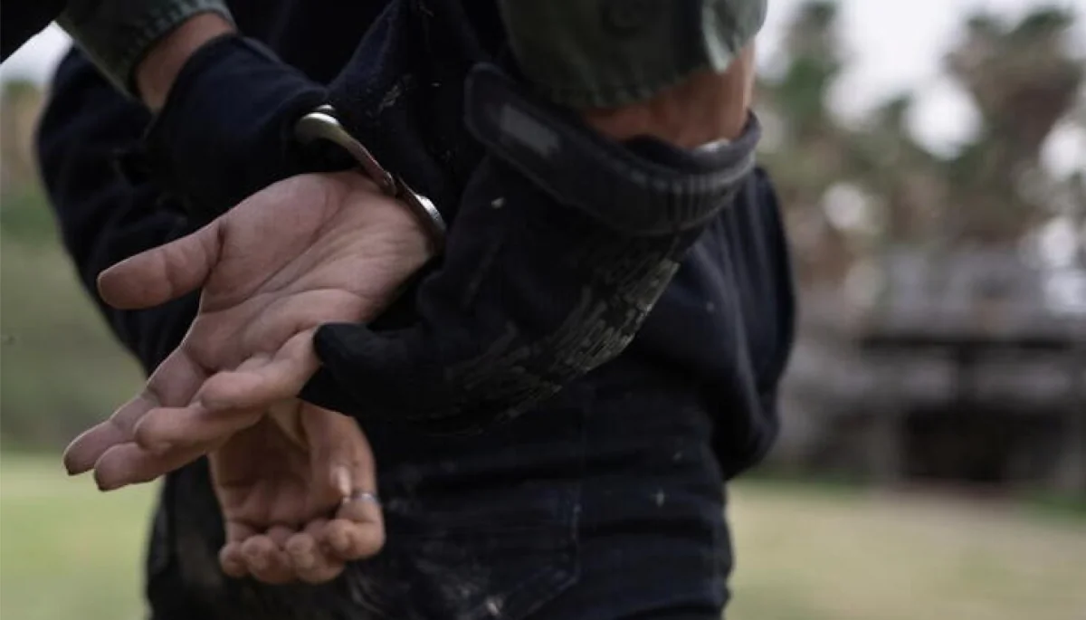 A law enforcement officer handcuffs a suspect in a file photo. (Adrees Latif/Reuters)
